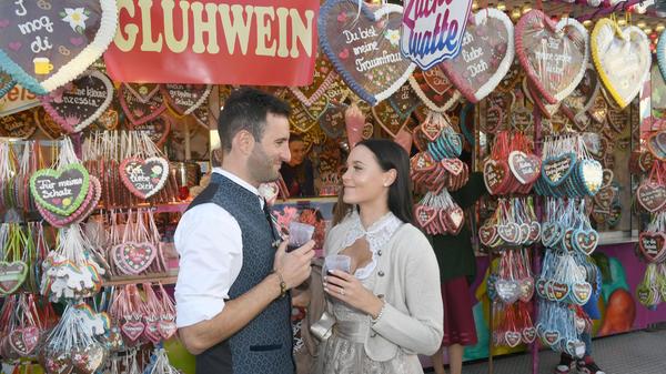 Der deutsch-rumänische Fußballspieler Maxi Nicu und Anniina Hiekkamäki stießen vor einem Lebkuchenherz-Stand miteinander an.