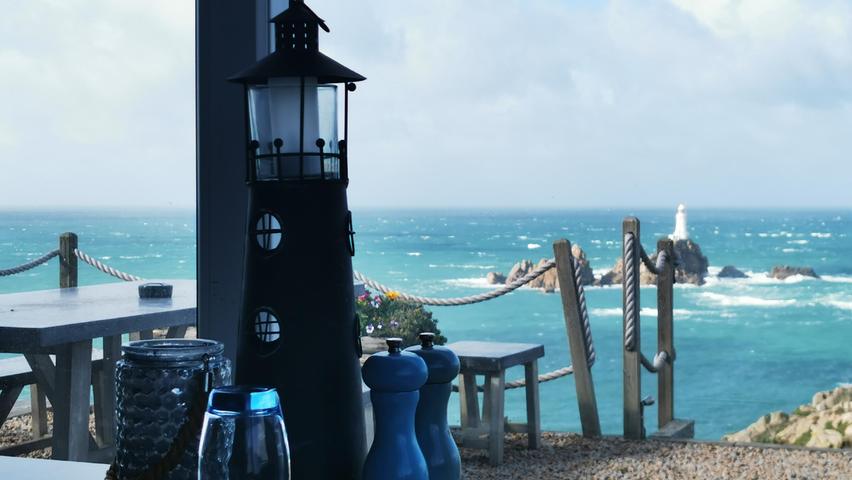 Blick aus dem Fenster des Restaurants am Corbiere Point auf den weißen Leuchtturm.