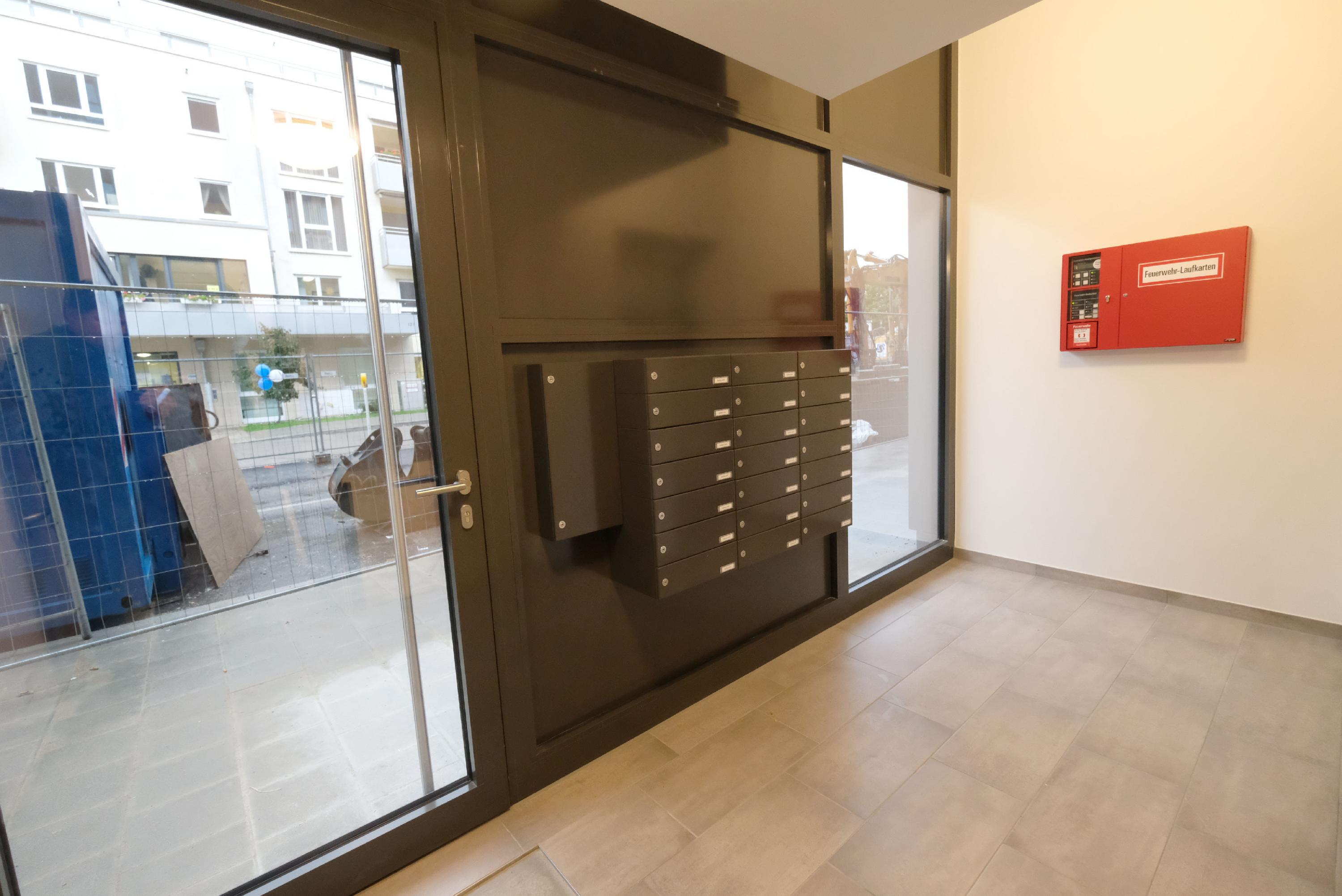 Willkommen! Auch der Eingangsbereich riecht noch nagelneu. Durch die Glastür ist zu erkennen, dass die Bauarbeiten im restlichen Quartier weiter gehen. Leiser wird es hier erst im Sommer 2023. Dann soll das "Seetor City Campus" endlich ganz und gar fertig sein. 