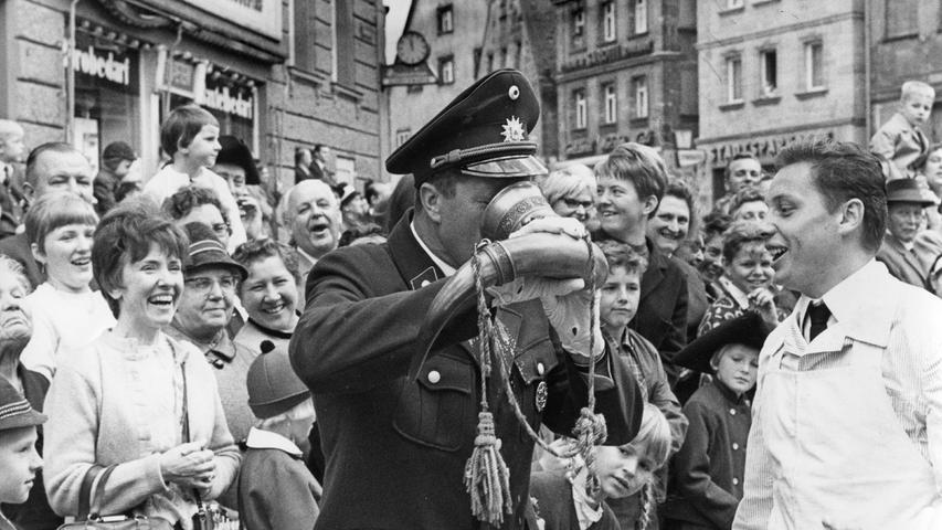 Von wegen „Ich trinke nicht, ich bin im Dienst . . .“: Im Oktober 1967 gönnt sich einer der eingeteilten Ordnungshüter am Rande des Kirchweih-Festzugs einen ordentlichen Schluck nahe dem Grünen Markt.