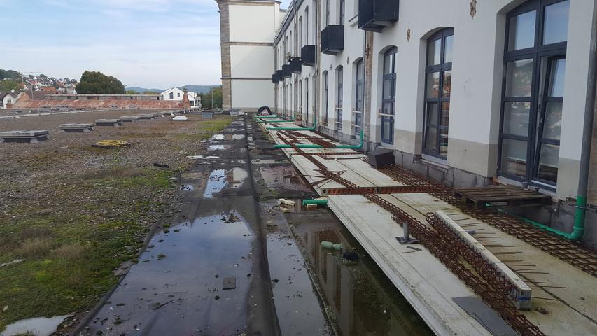 Dachterrassen-Baustelle auf der Nordseite des Gebäudekomplexes: Regenwasser läuft über Behelfsrohre aufs Dach der direkt angrenzenden Supermärkte.