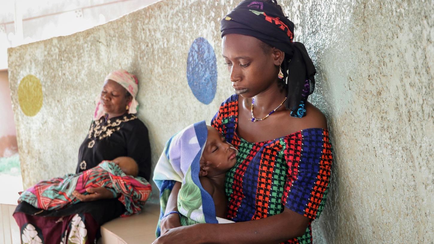 Burkina Faso: Eine Mutter (r.) hält ihren zweijährigen Sohn, der wegen Unterernährung mit einer Magensonde behandelt wird.