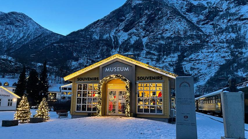 Auch Flåm verwandelt sich in der Weihnachtszeit in ein Winterwunderland.  Im Bild ist ein Museum zu sehen, im Hintergrund sind die Berge.