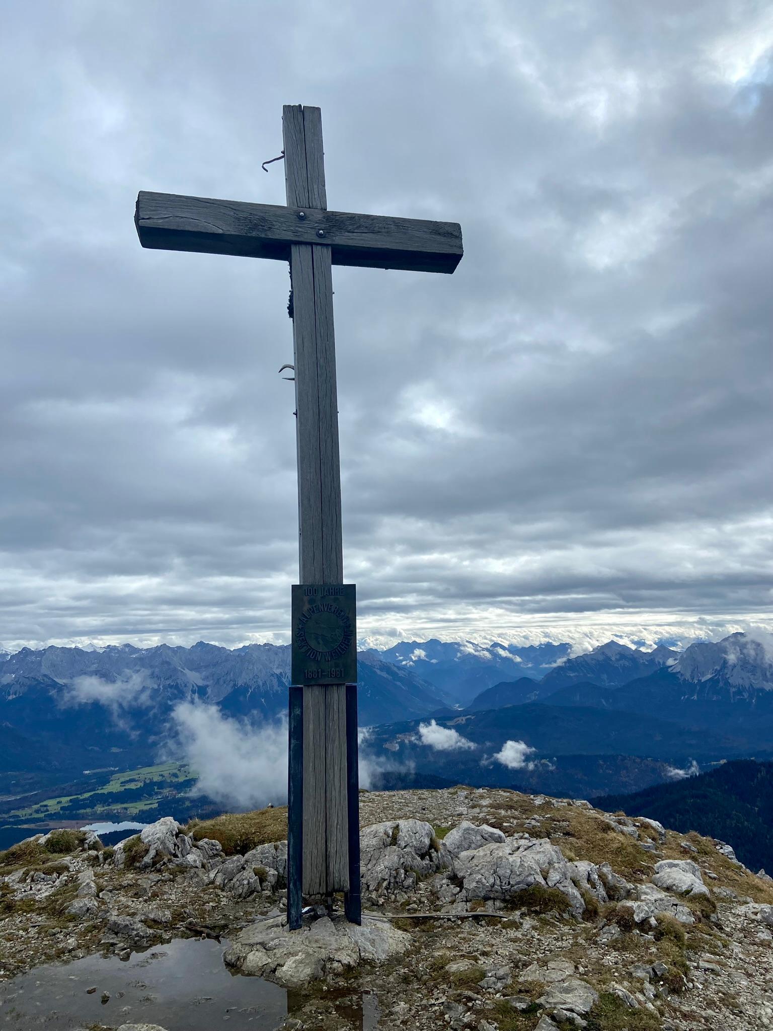 Im Hintergrund das Karwendelgebirge, im Vordergrund das Gipfelkreuz des Krottenkopfes. 