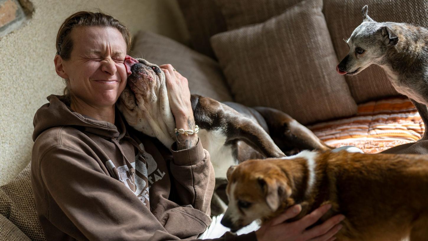 Stephanie Badura sitzt auf dem Sofa in ihrem Wohnzimmer und kuschelt mit ihren Pflegehunden. Stephanie Badura sitzt auf dem Sofa in ihrem Wohnzimmer und kuschelt mit ihren Pflegehunden.