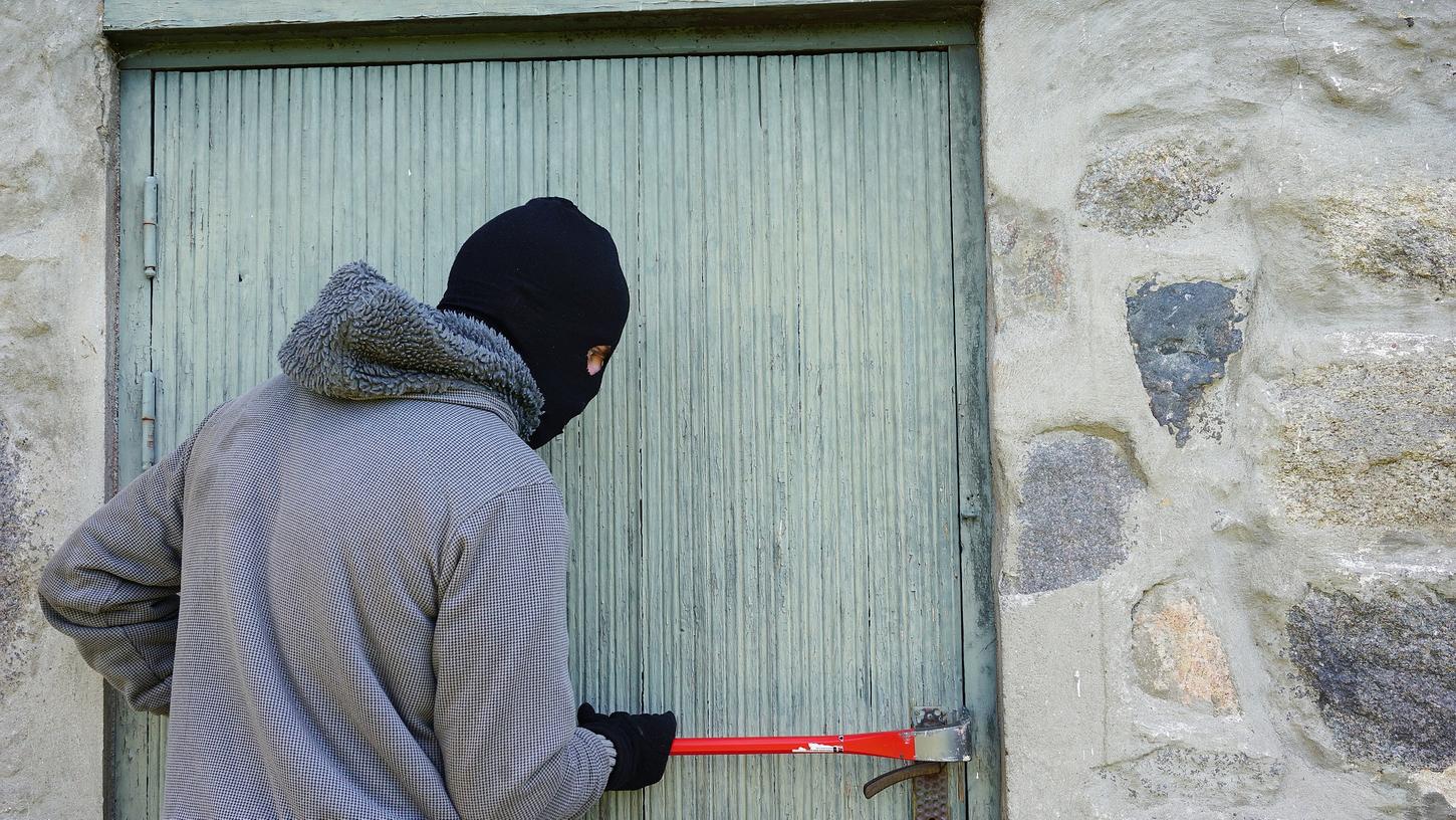 Ein Einbrecher versucht eine Türe aufzustemmen. Gerade in der dunklen Jahreszeit häufen sich die Einbrüche. Ein Einbrecher versucht eine Türe aufzustemmen. Gerade in der dunklen Jahreszeit häufen sich die Einbrüche.