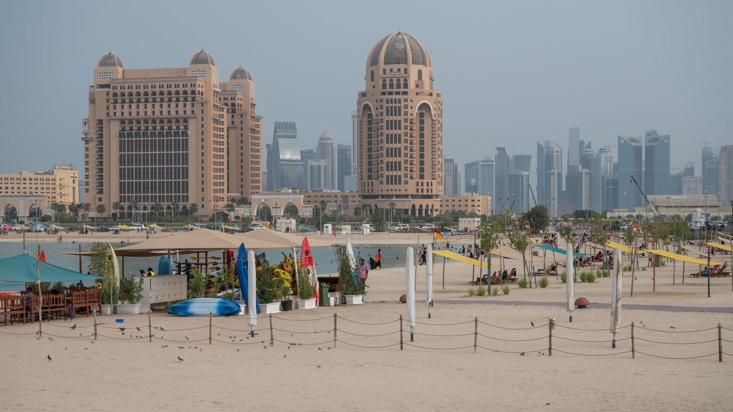 Strandleben in Doha: Baden im persischen Golf mit Blick auf die Skyline.