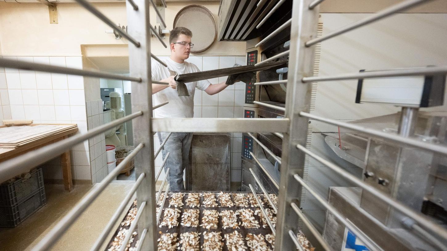 Der Pfefferküchler-Meister Martin Kotzsch nimmt in der Backstube der Pfefferküchlerei Hermann Löschner ein Backblech mit Pfefferkuchen aus dem Ofen. Der Pfefferküchler-Meister Martin Kotzsch nimmt in der Backstube der Pfefferküchlerei Hermann Löschner ein Backblech mit Pfefferkuchen aus dem Ofen.