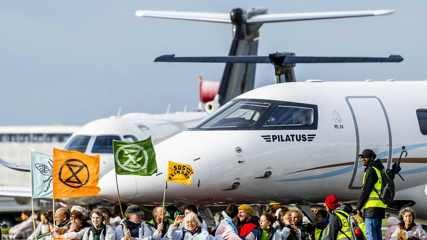 Klima-Aktivisten blockieren Privatjets auf dem Flughafen Schiphol. Klima-Aktivisten blockieren Privatjets auf dem Flughafen Schiphol.