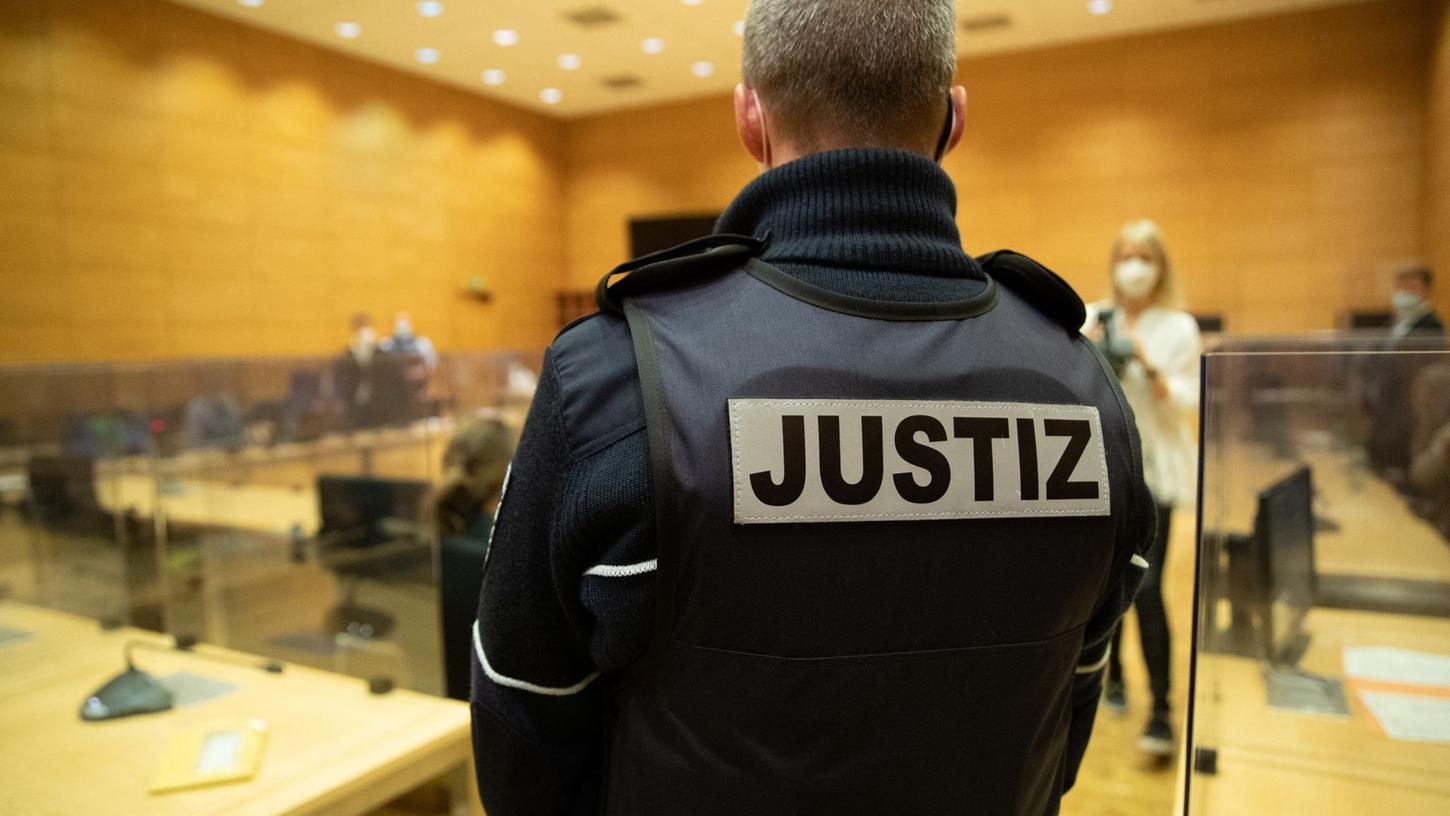 Ein Justizbeamter steht in einem Gerichtssaal. Ein Justizbeamter steht in einem Gerichtssaal.