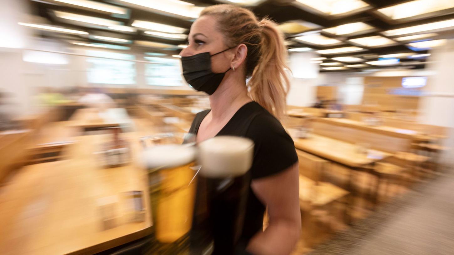 Eine Kellnerin in einem gastronomischen Betrieb in Stuttgart Getränke an einen Tisch. Eine Kellnerin in einem gastronomischen Betrieb in Stuttgart Getränke an einen Tisch.