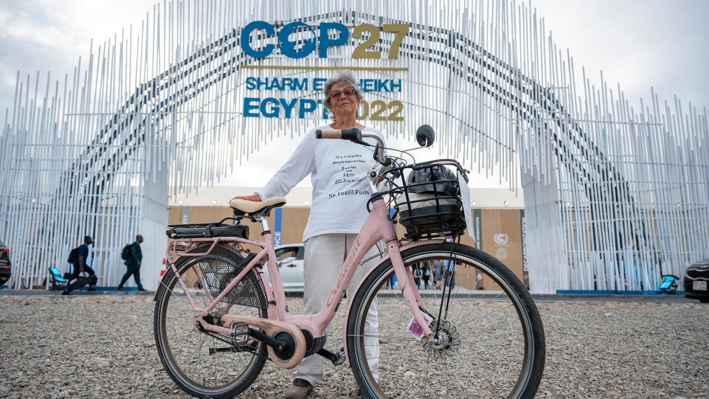 Dorothee Hildebrandt steht mit ihrem Fahrrad vor dem Eingang vom UN-Klimagipfel COP27. Die 72-Jährige ist mit ihrem Fahrrad von Schweden aus 8228 km bis zur COP27 gefahren.