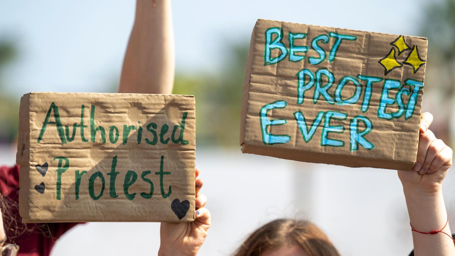 Protestierende der Fridays for Future Bewegeung halten Plakate in die Höhe. Protestierende der Fridays for Future Bewegeung halten Plakate in die Höhe.