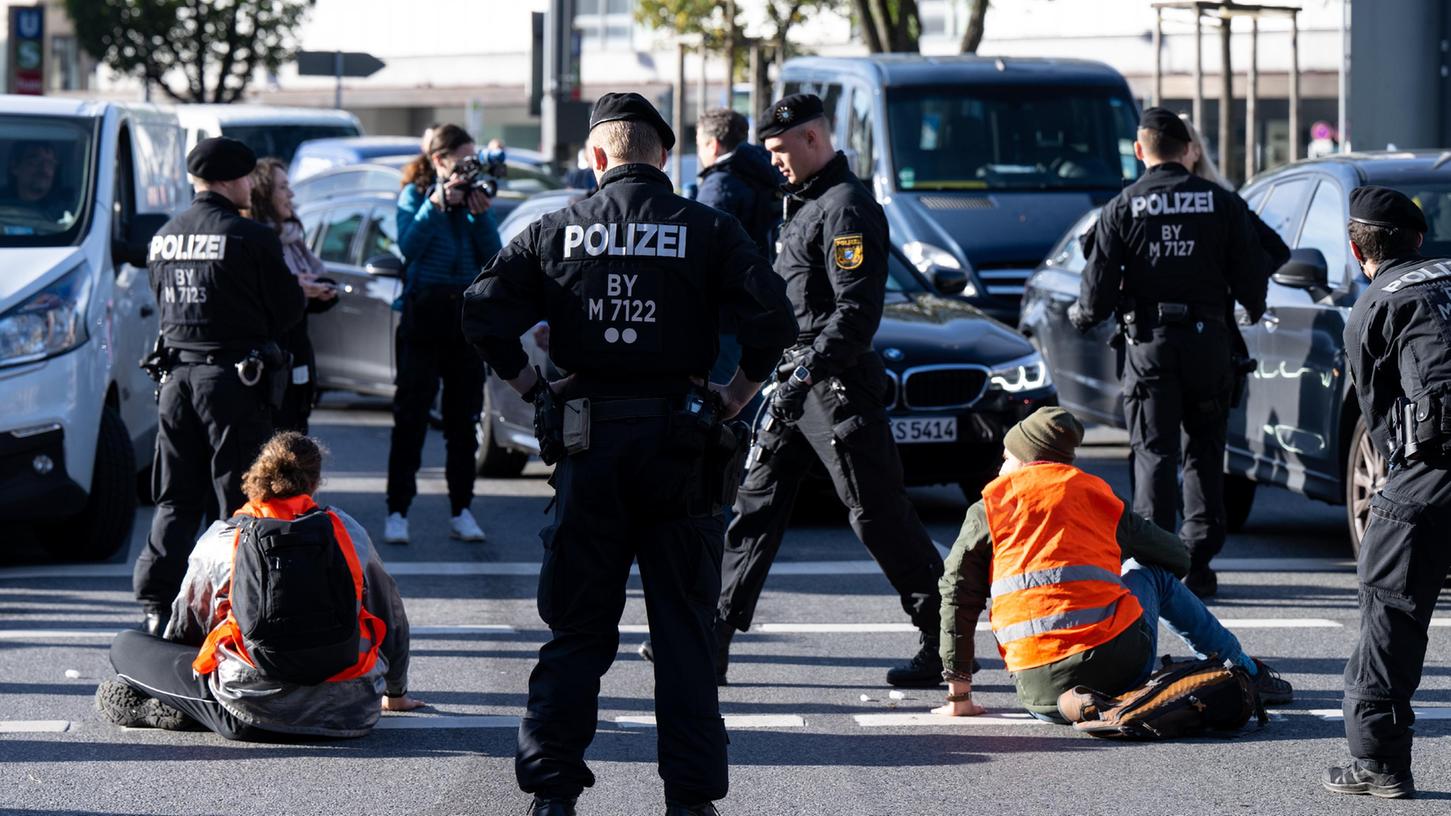Mehrere Klimaaktivisten, die sich in München auf der Straße festgeklebt wurden, sind in München in Gewahrsam. Einer von ihnen hat nun zu einer drastischen Maßnahme gegriffen.
