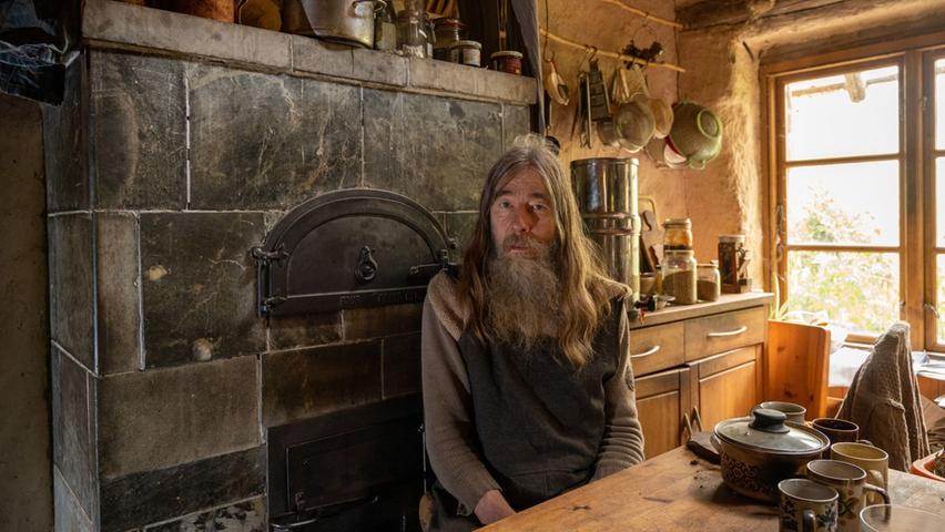 Friedmunt Sonnemann heizt seine Lehmhütte mit Holz.