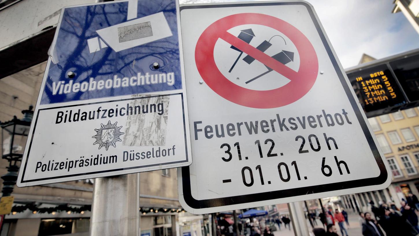 Hinweisschilder auf Videoüberwachung und Böllerverbot hängen am Zugang zur Altstadt in Düsseldorf.