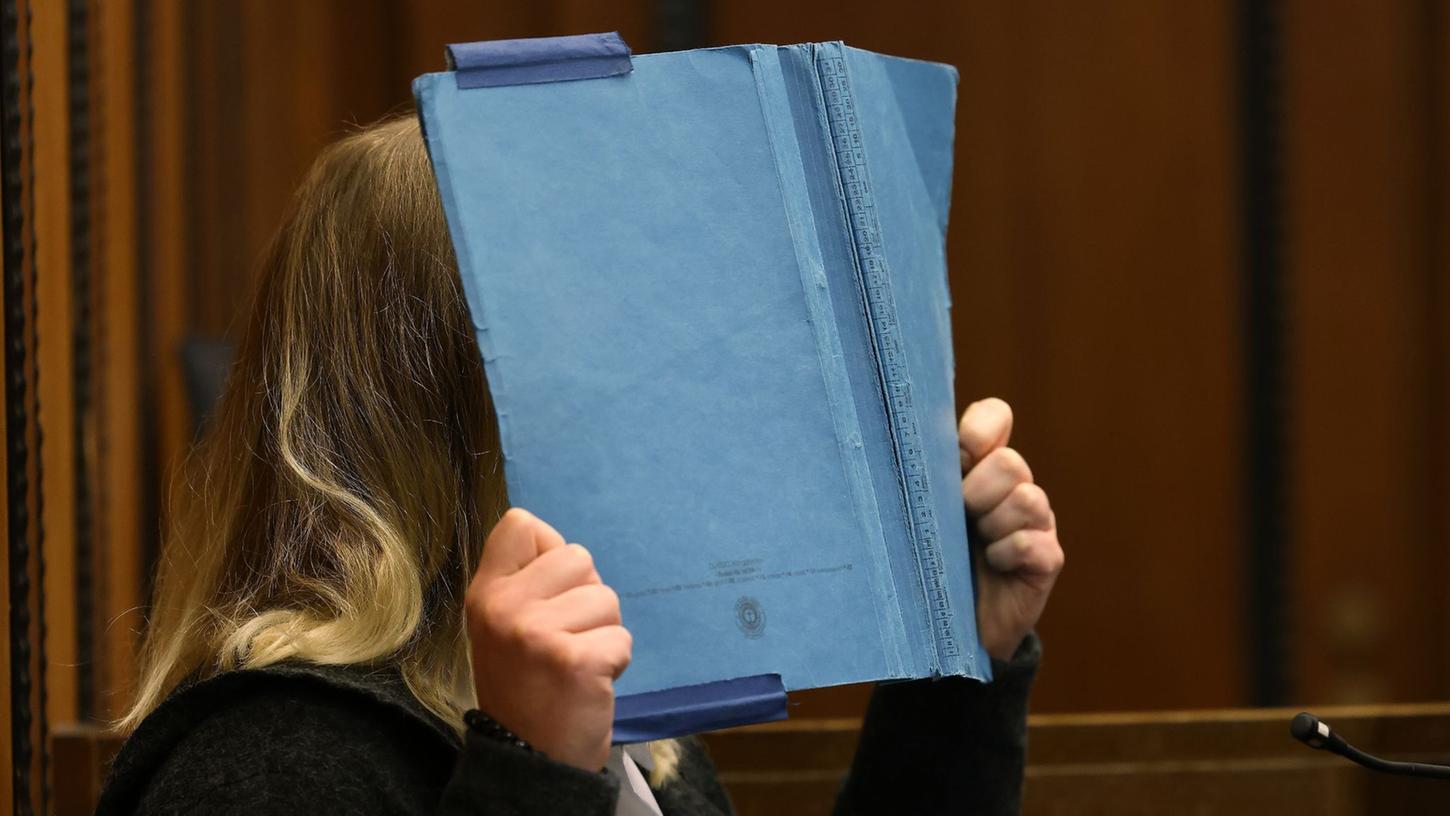 Die Angeklagte deckt im Landgericht ihr Gesicht mit einem blauen Ordner ab. Rund acht Monate nach der Entdeckung eines getöteten Babys in Mönchengladbach beginnt der Prozess gegen die Mutter des Kindes.