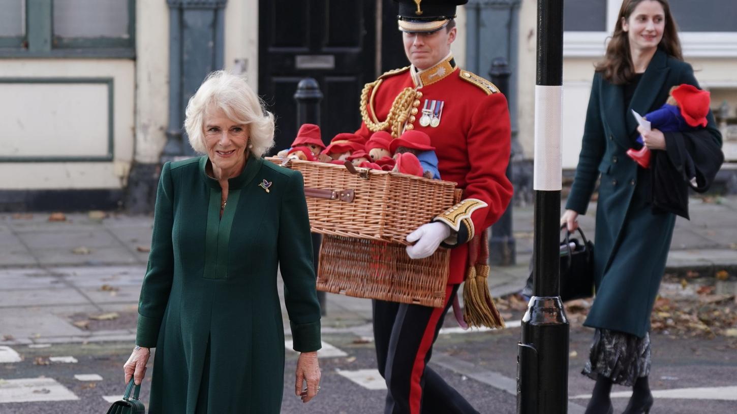Königsgemahlin Camilla (l) bringt Paddington-Plüschtiere in die  Barnardo's-Kindertagesstätte in London.