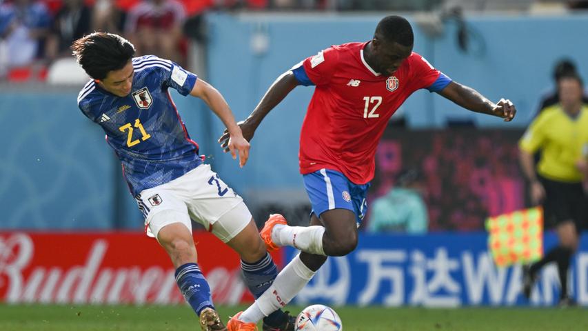 Ayase Ueda (l)aus Japan und Joel Campbell aus Costa Rica kämpfen um den Ball.