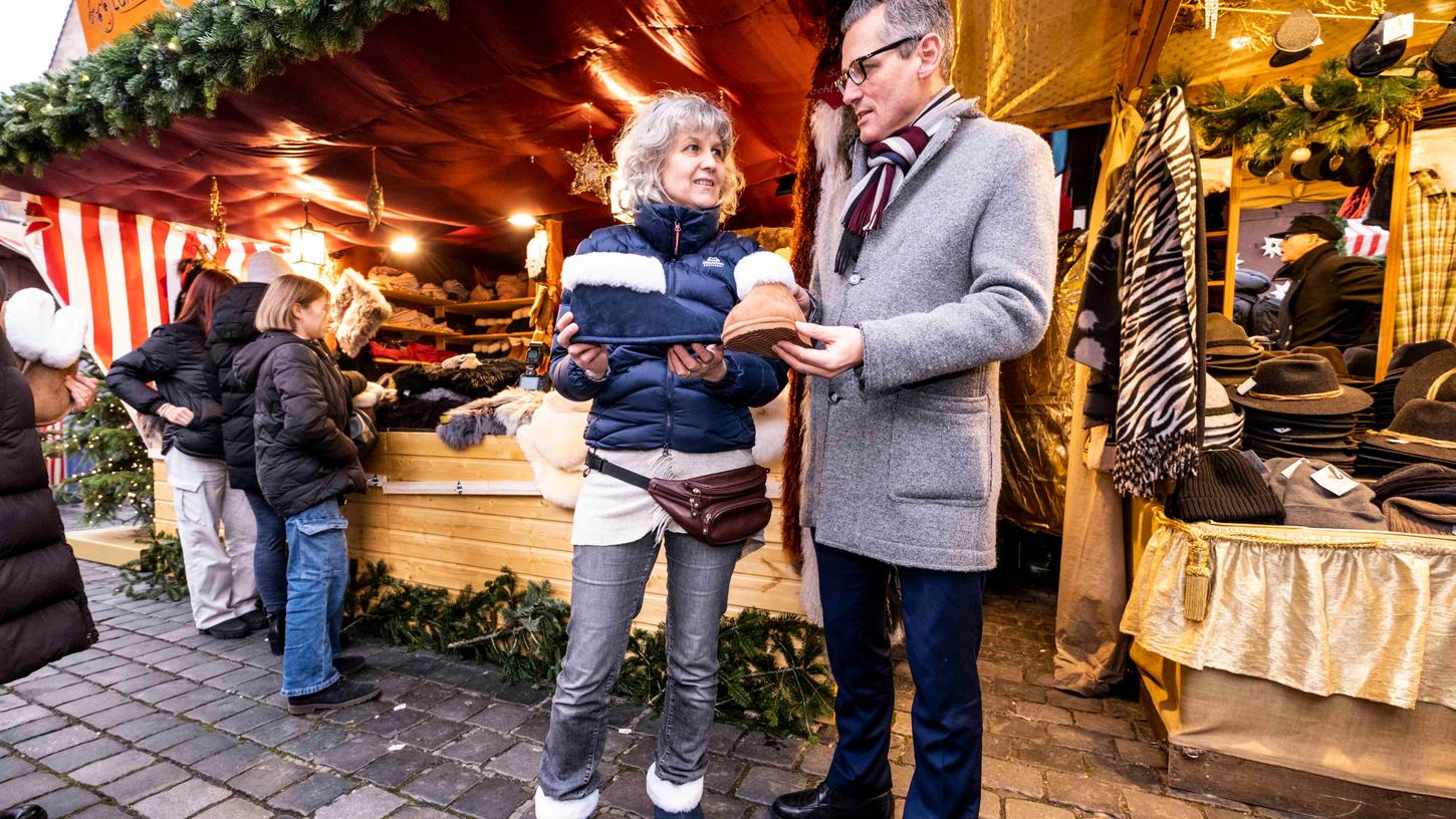 Vielleicht ein Weihnachtsgeschenk: Wirtschaftsreferent Michael Fraas lässt sich von Anja Facchini Hausschuhe aus Lammwolle zeigen.