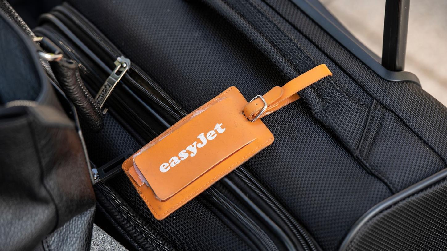 Ein Adressanhänger mit dem Logo von Easyjet ist an einem Koffer befestigt.