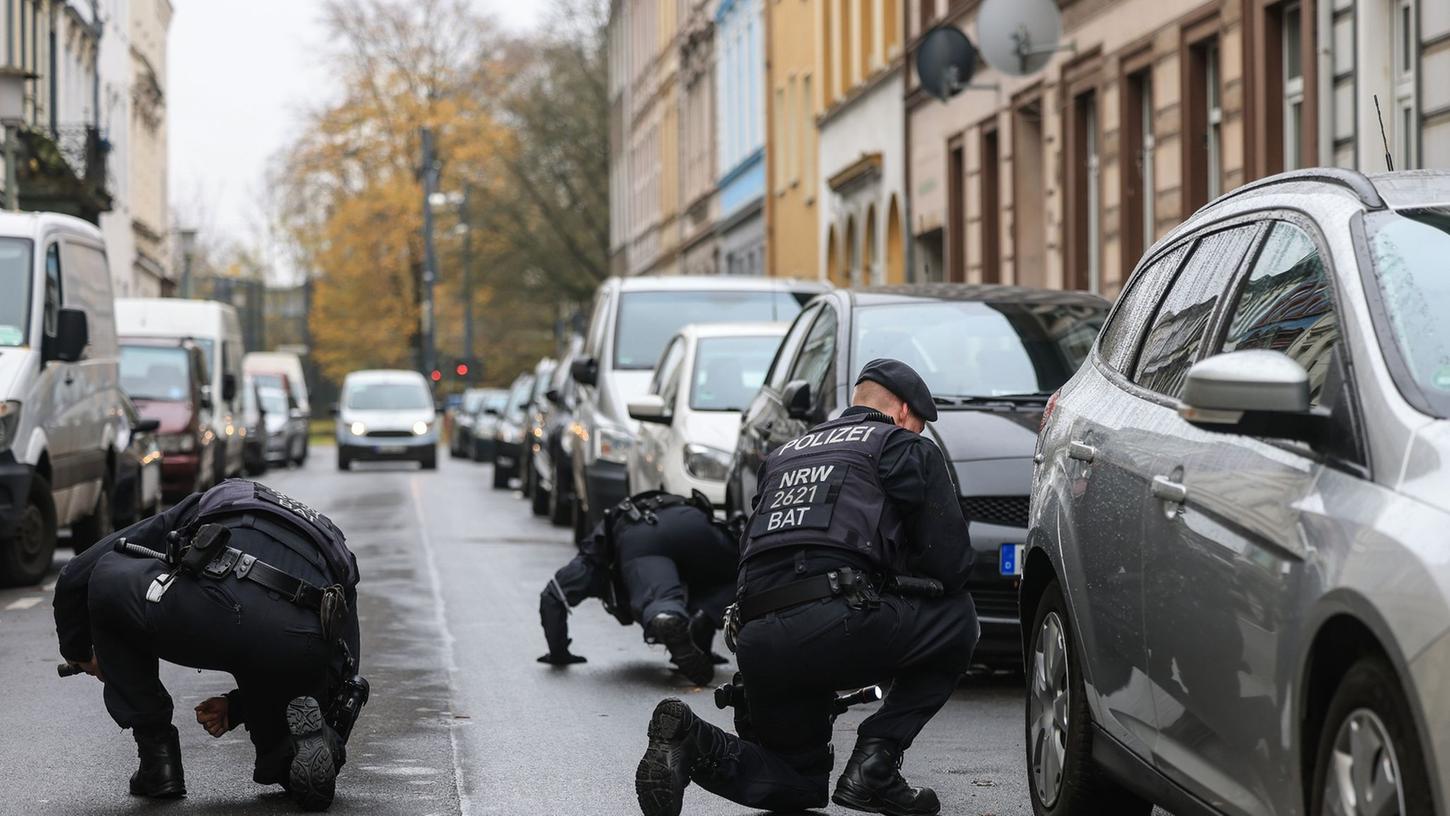 Polizisten suchen in der Nähe des Tatortes in Krefeld nach Spuren.