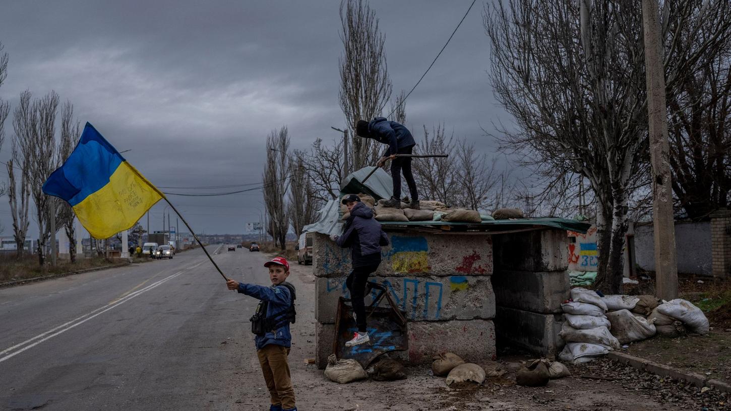 Ukrainische Kinder spielen an einem verlassenen Kontrollpunkt in Cherson
