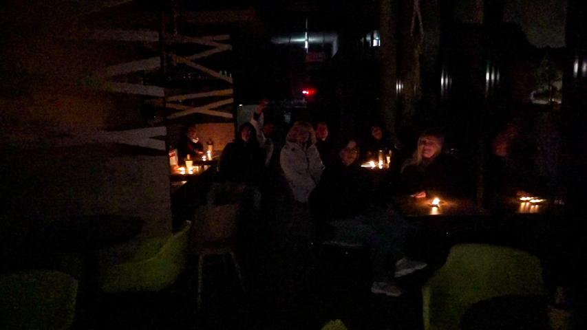 Im Kerzenschein und mit Winterjacken warten die Strullendorfer in der Bäckerei Fuchs auf den Strom.
