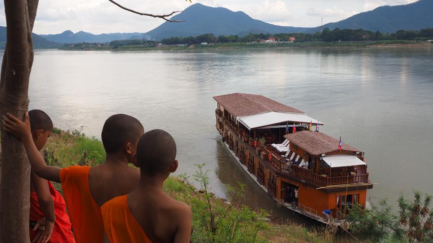 Nahe Vientiane, der Hauptstadt von Laos, begutachten junge Mönche das Kreuzfahrtschiff.
