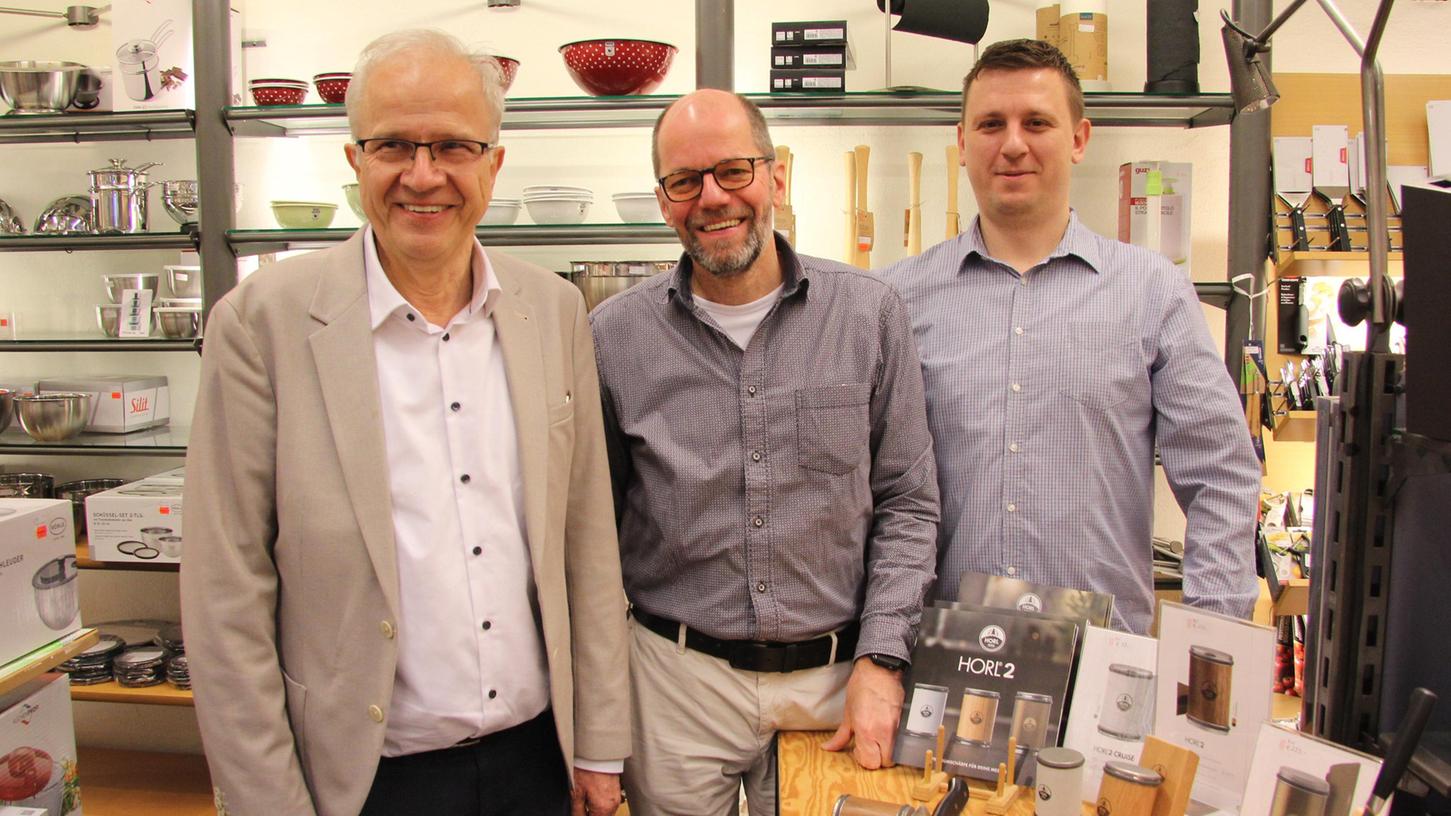 Geschäftsführer Klaus Harl (links) mit Prokurist Roland Schmidt (Mitte) und Mitarbeiter Andreas Michl vor der neusten Innovation bei "Küchen Loesch": einem Messerschleifer. 
