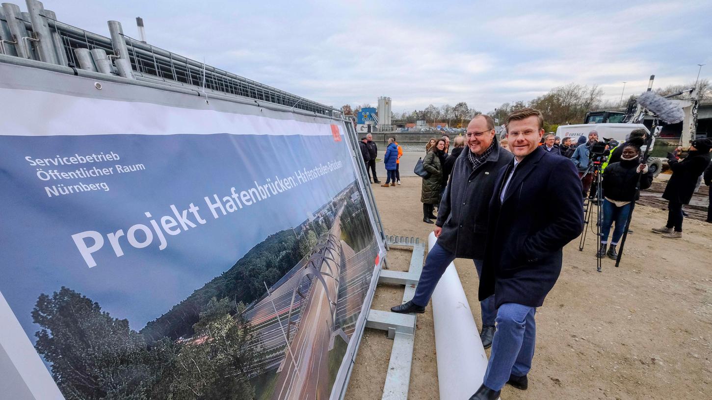 Von links: Nürnbergs dritter Bürgermeister Christian Vogel (SPD) und Oberbürgermeister Marcus König (CSU). Auf dem Plakat ist eine Visualisierung der neuen Hafenstraßen-Brücken zu erkennen. Von links: Nürnbergs dritter Bürgermeister Christian Vogel (SPD) und Oberbürgermeister Marcus König (CSU). Auf dem Plakat ist eine Visualisierung der neuen Hafenstraßen-Brücken zu erkennen.