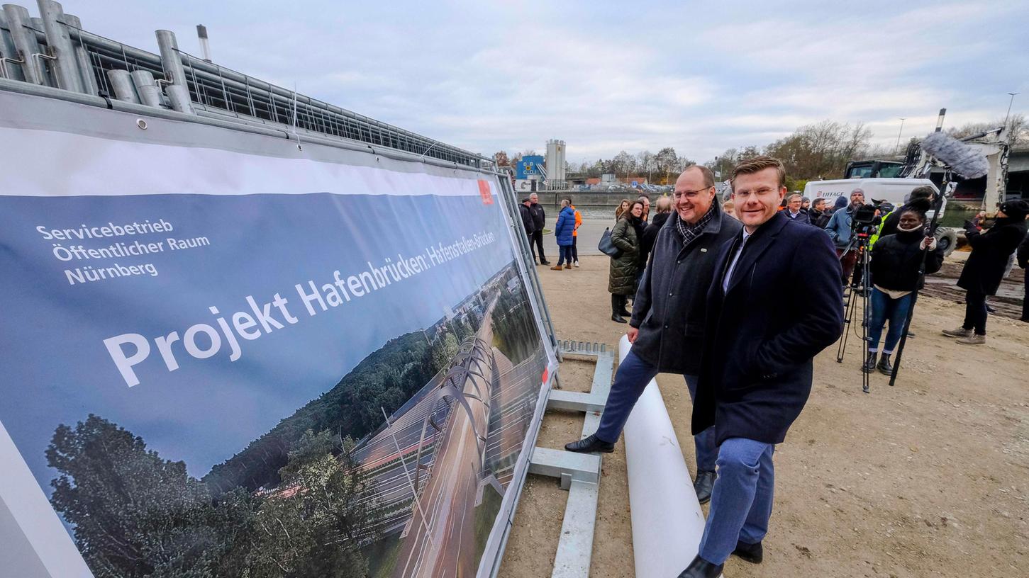 Von links: Nürnbergs dritter Bürgermeister Christian Vogel (SPD) und Oberbürgermeister Marcus König (CSU). Auf dem Plakat ist eine Visualisierung der neuen Hafenstraßen-Brücken zu erkennen.