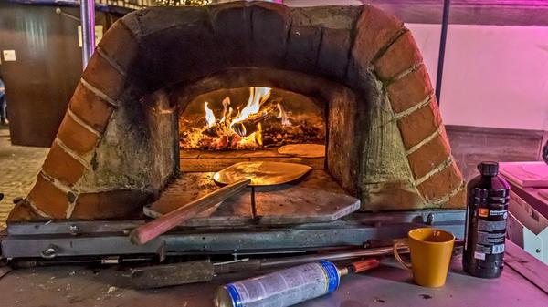 Fröhlich flackert das Feuer im Ofen des Fladenbäckers.