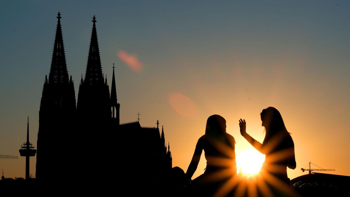 Zwei Frauen vor dem Kölner Dom:  Beim ersten Date verzichten junge Leute nach Tinder-Angaben heutzutage lieber auf Alkohol und treffen sich zu kulturellen Aktivitäten oder draußen statt im Restaurant.