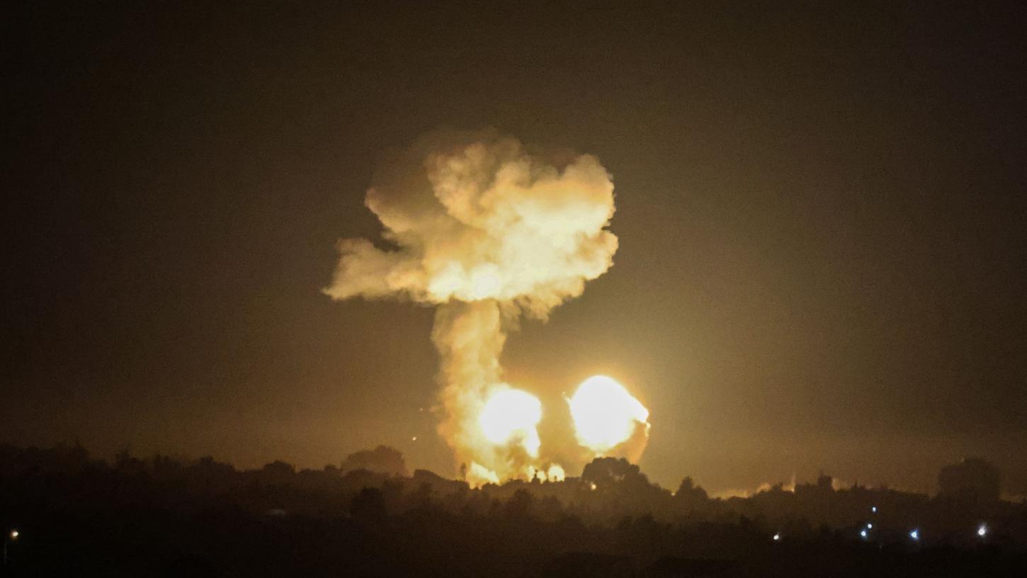 Ein Feuerball und eine Rauchwolke steigen während eines Luftangriffs über Gebäuden auf.