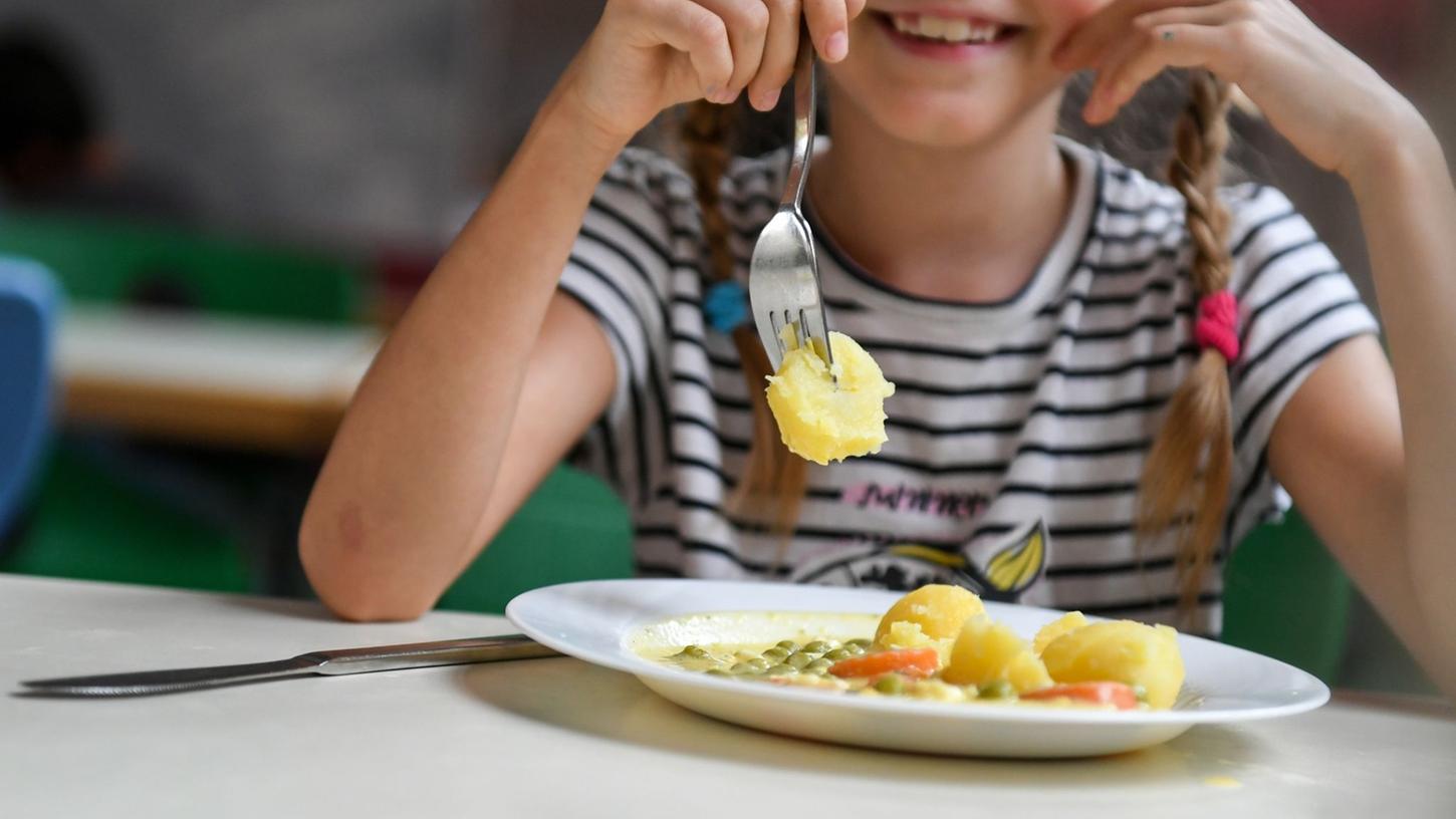 Schüler sitzen beim Mittagessen in der Mensa einer Grundschule.