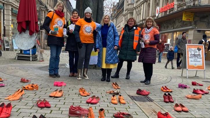 Am Dreiherrenbrunnen in der Fürther Fußgängerzone erinnerten über 100 Paar verwaiste Schuhe in rot und orange an getötete Frauen und Mädchen.