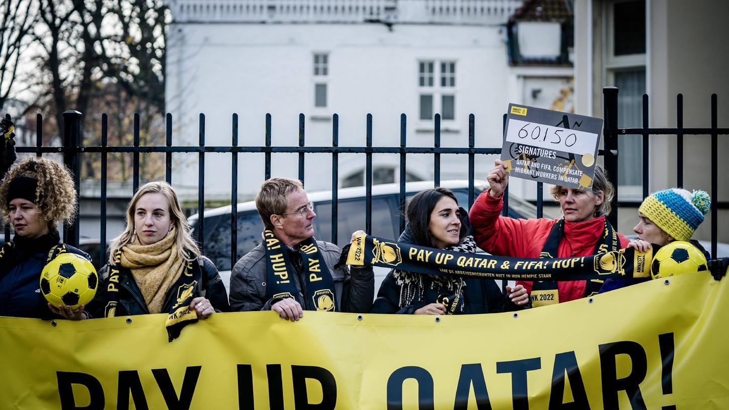 Bezahlt dafür: Mitglieder von Amnesty International demonstrieren in Den Haag für Kompensationszahlungen an Arbeitsmigranten in Katar. 