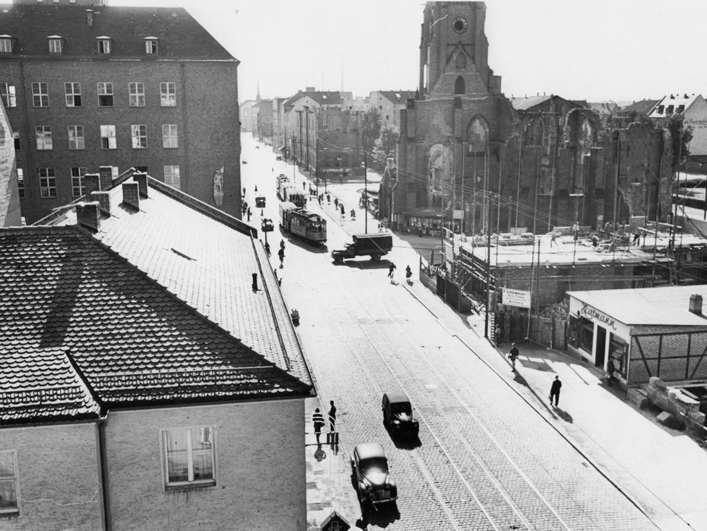Die undatierte Aufnahme stammt aus den ersten Nachkriegsjahren. An der Landgrabenstraße sind neben den ausgebrannten Ruinen der Kirche schon wieder neue Wohnhäuser entstanden – rechts herrschen noch Provisorien und Baustelle.  