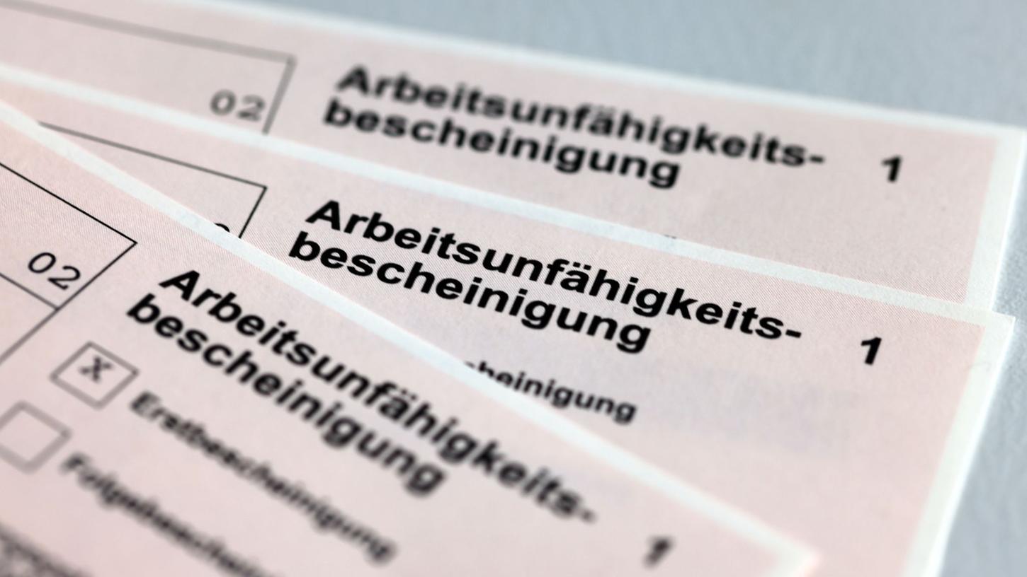 Arbeitsunfähigkeitsbescheinigungen für Arbeitnehmer liegen auf einem Tisch.