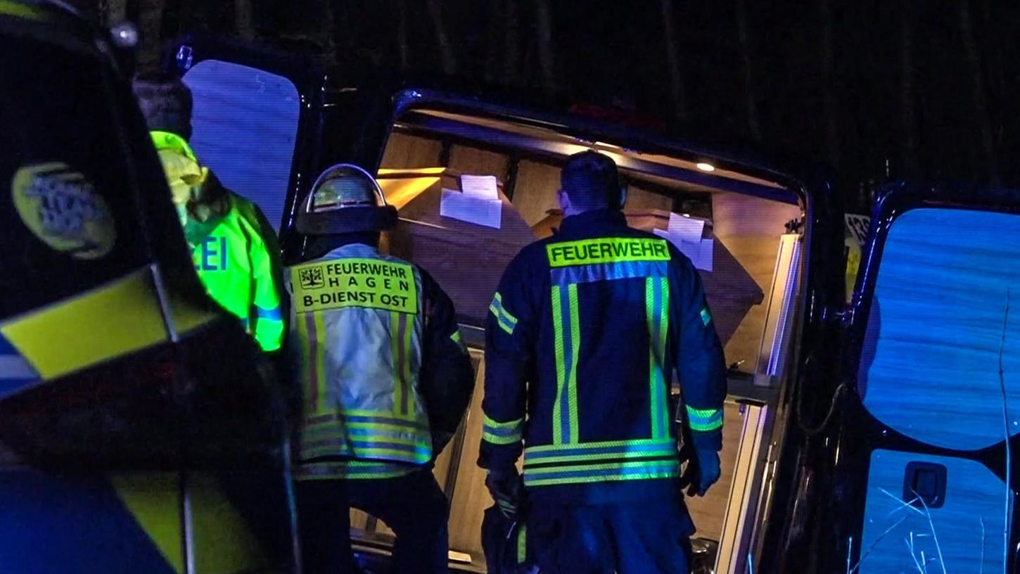 Einsatzkräfte stehen vor einem verunglückten Leichenwagen. Einsatzkräfte stehen vor einem verunglückten Leichenwagen.