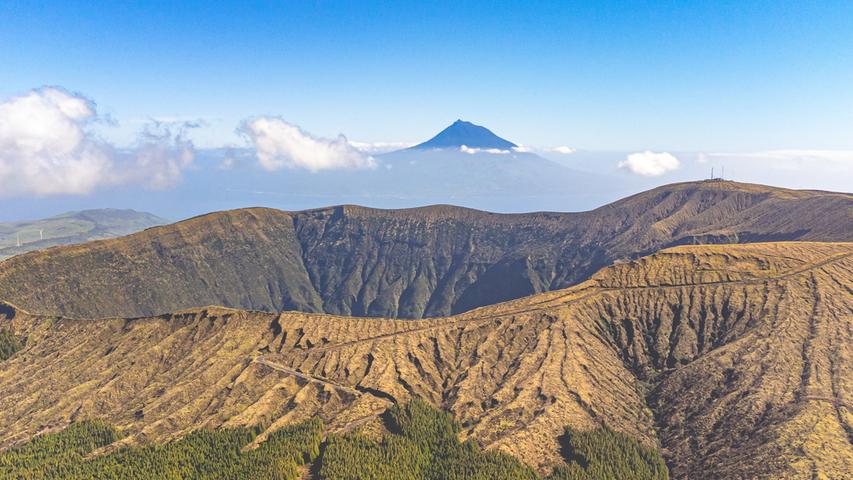 Auf dem nahezu höchsten Punkt Faials geht es plötzlich 400 Meter tief nach unten. Nicht nur der Krater des Vulkans Cabeço Gordo, auch der Berg der Nachbarinsel Pico im Hintergrund ist beeindruckend.