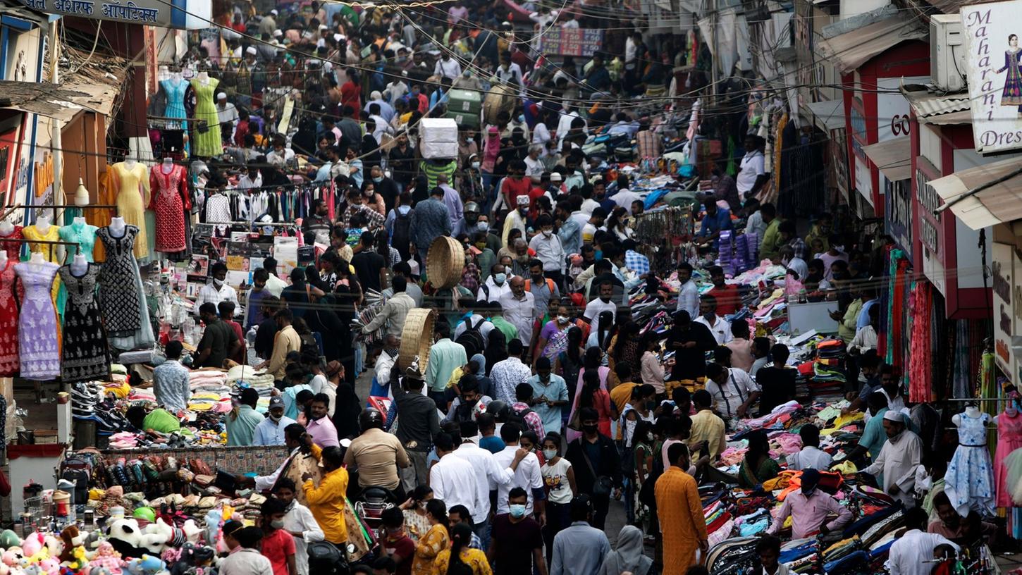 Zahlreiche Menschen sind auf einem Markt in Mumbai unterwegs.