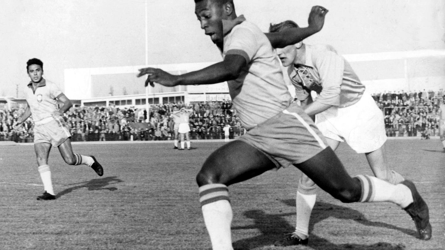 August, 1960 in Malmö: Der frühere brasilianische Star-Stürmer Pele (vorn) hat bei einem Freundschaftsspiel einen Abwehrspieler von Malmö FF überrannt und schießt aus vollem Lauf ein Tor zum 5:1.