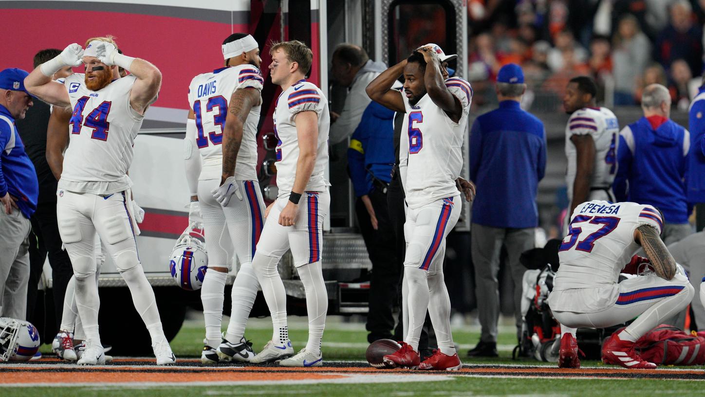 Spieler der Buffalo Bills reagieren geschockt, als ihr Teamkollege Damar Hamlin untersucht wird. Spieler der Buffalo Bills reagieren geschockt, als ihr Teamkollege Damar Hamlin untersucht wird.