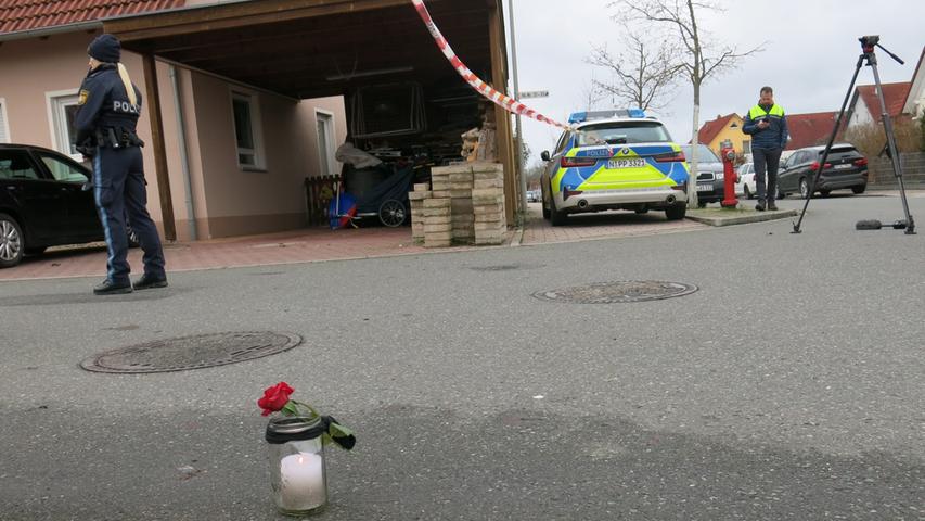 An der abgesperrten Einfahrt zu der Straße, wo sich das Familiendrama ereignete, haben Bekannte der Opfer als Ausdruck der Betroffenheit und Trauer eine Kerze aufgestellt.
