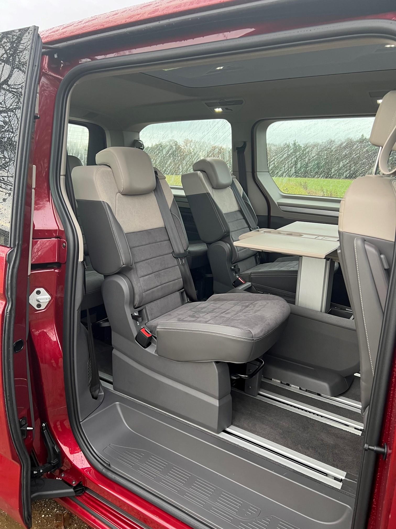 Der höhenverstellbare und ausklappbare Multifunktionstisch kann je nach Bedarf als Mittelkonsole zwischen den Vordersitzen genutzt oder auf Schienen nach hinten verschoben werden.