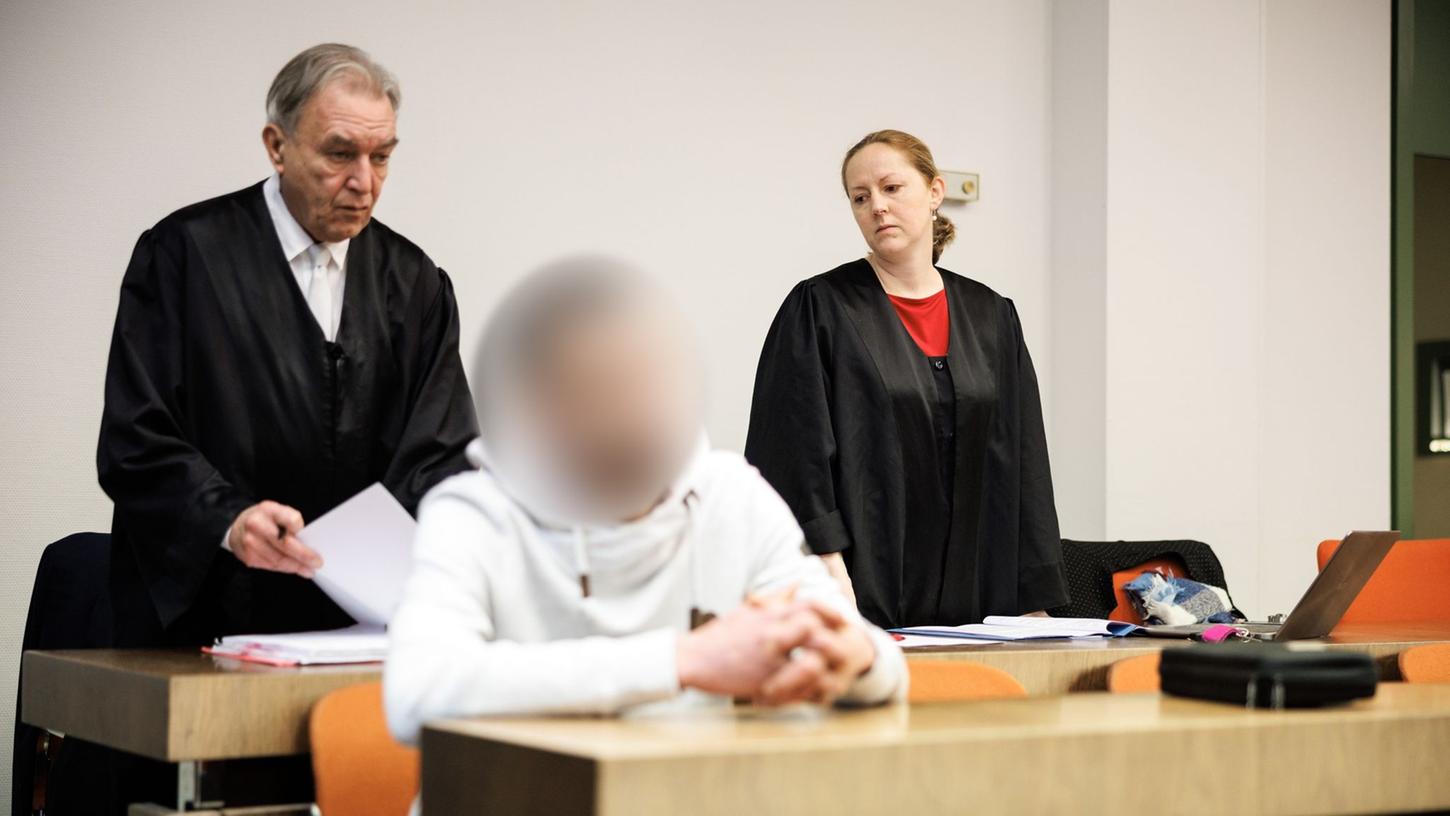 Der wegen Totschlags angeklagte Mann (m.), der seine fünf Wochen alte Tochter umgebracht haben soll, in einem Gerichtssaal in München.