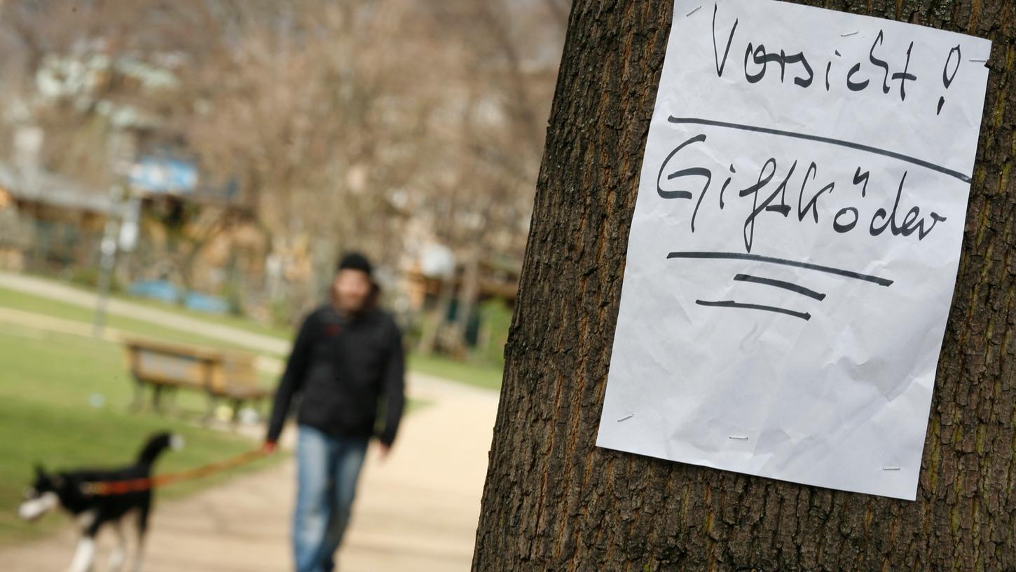 Ein Zettel warnt in einem Park vor Giftködern. (Archivbild)