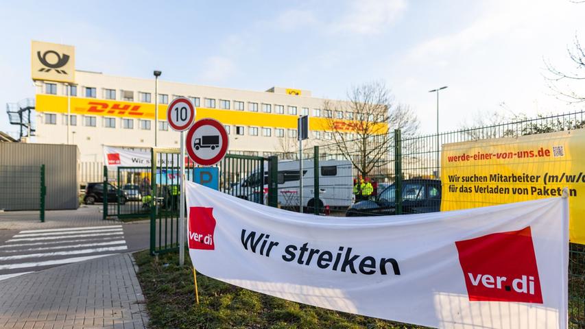 Ein Banner mit der Aufschrift "Wir streiken" hängt vor einem Gebäude des Paketdienstleisters DHL in Lahn. Ein Banner mit der Aufschrift "Wir streiken" hängt vor einem Gebäude des Paketdienstleisters DHL in Lahn.